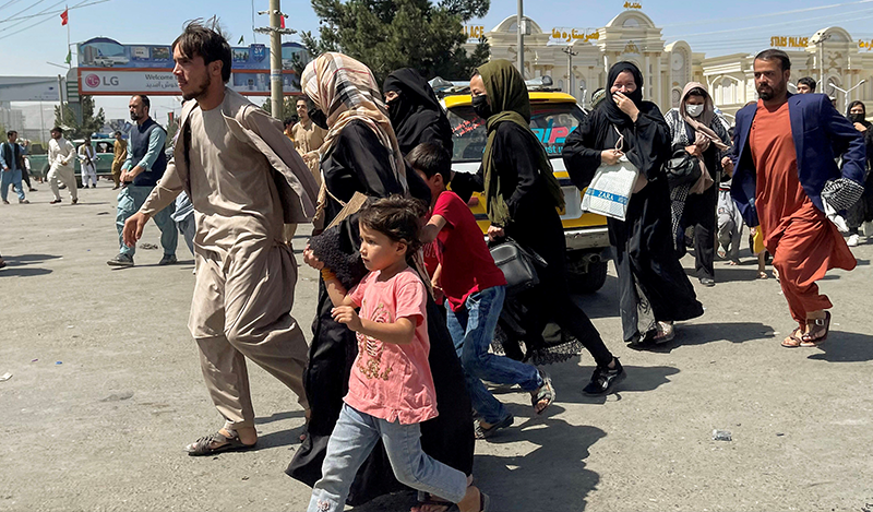 People try to get into Hamid Karzai International Airport in Kabul, Afghanistan August 16, 2021. REUTERS
