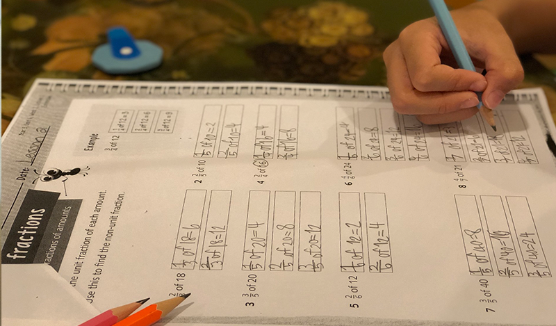 Young male student takes a maths quiz in class