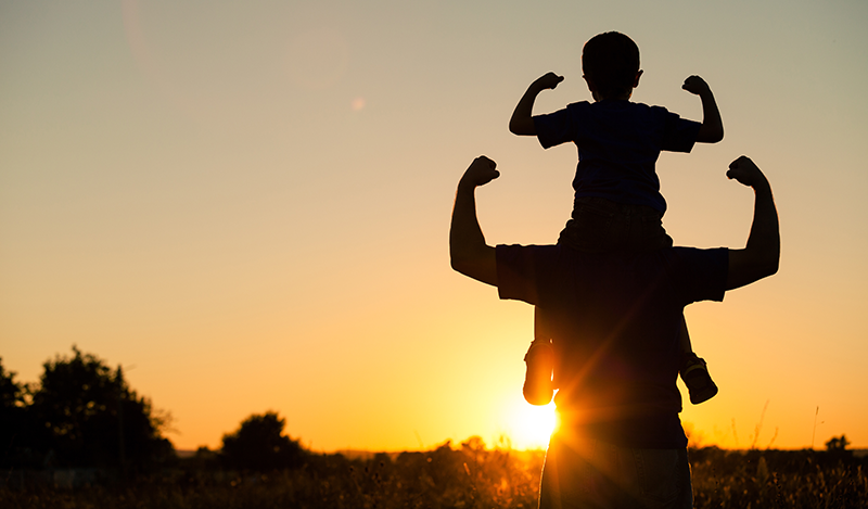 father and son together against a setting sun